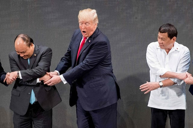 as other people clutched the person to their left and their right us president donald trump c used both of his hands to clasp the extended fingers of vietnam 039 s prime minister nguyen xuan phuc l photo afp as other people clutched the person to their left and their right us president donald trump c used both of his hands to clasp the extended fingers of vietnam 039 s prime minister nguyen xuan phuc l photo afp