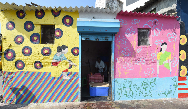 this photo taken on november 9 2017 shows a fisherman packing crates of fish with ice at his shop with the walls painted for the st art festival at sassoon dock one of the oldest fishing docks in mumbai photo afp