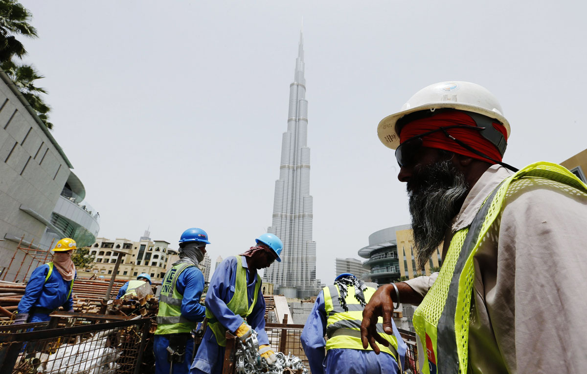 labourers work near the burj khalifa the tallest tower in the world in dubai in this may 9 2013 file photo photo reuters