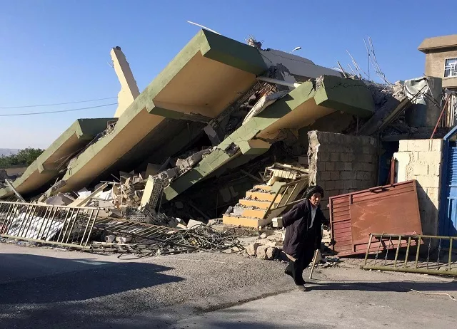 a man walks past a damaged building following an earthquake in darbandikhan in sulaimaniya governorate iraq november 13 2017 photo reuters