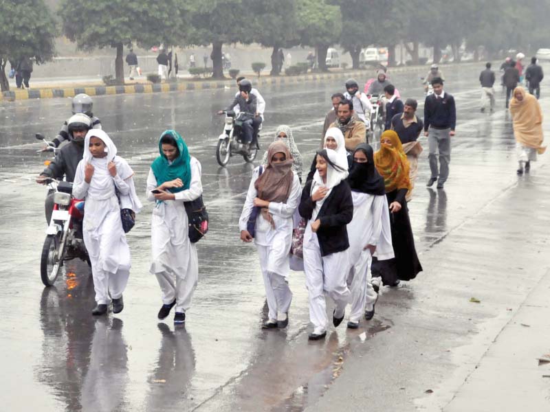 students walk home drenched in rain due to blockade of tlyra photo zafar aslam express