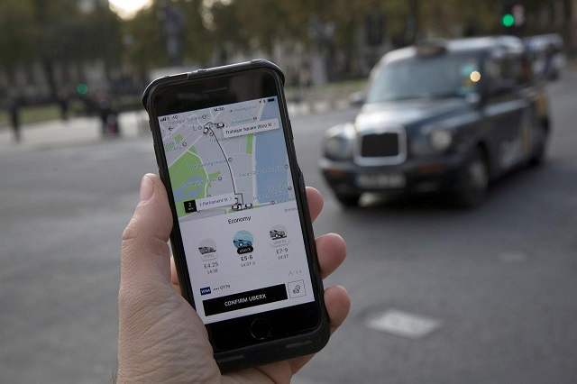 a photo illustration shows the uber app on a mobile telephone as it is held up for a posed photograph with a london taxi in the background in london britain november 10 2017 photo reuters