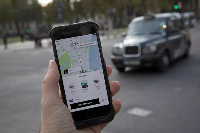 a photo illustration shows the uber app on a mobile telephone as it is held up for a posed photograph with a london taxi in the background in london britain november 10 2017 photo reuters a photo illustration shows the uber app on a mobile telephone as it is held up for a posed photograph with a london taxi in the background in london britain november 10 2017 photo reuters