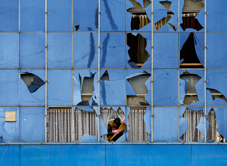 a man removes broken glass from a building after a suicide bomb attack in kabul afghanistan photo reuters