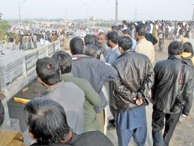 people gather to catch a glimpse of protesters sitting at faizabad photo online people gather to catch a glimpse of protesters sitting at faizabad photo online