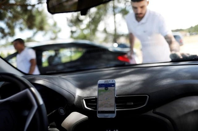 an uber driver cleans his car as his cell phone shows the queue to pick up passengers departing guarulhos international airport in sao paulo brazil february 13 2017 photo reuters an uber driver cleans his car as his cell phone shows the queue to pick up passengers departing guarulhos international airport in sao paulo brazil february 13 2017 photo reuters