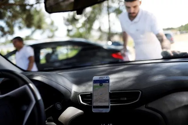 an uber driver cleans his car as his cell phone shows the queue to pick up passengers departing guarulhos international airport in sao paulo brazil february 13 2017 photo reuters an uber driver cleans his car as his cell phone shows the queue to pick up passengers departing guarulhos international airport in sao paulo brazil february 13 2017 photo reuters
