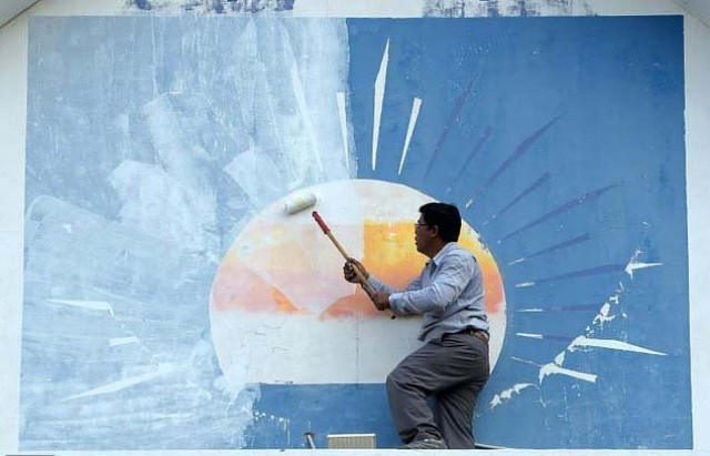 a supporter of the opposition cambodia national rescue party paints over the party logo at its headquarters after the party was banned photo afp a supporter of the opposition cambodia national rescue party paints over the party logo at its headquarters after the party was banned photo afp