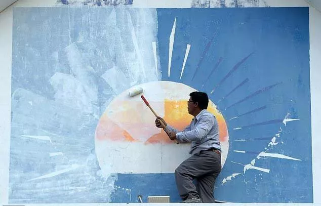 a supporter of the opposition cambodia national rescue party paints over the party logo at its headquarters after the party was banned photo afp a supporter of the opposition cambodia national rescue party paints over the party logo at its headquarters after the party was banned photo afp
