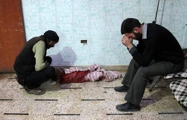 syrian men mourn a child in a makeshift clinic following shelling of the rebel held town of douma photo afp