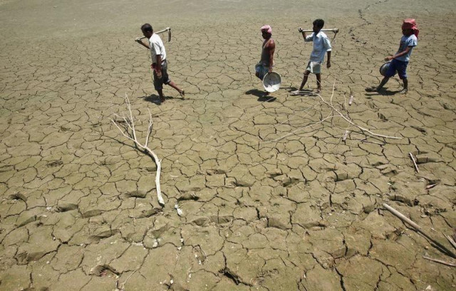 labourers walk through a parched land of a dried lake photo reuters labourers walk through a parched land of a dried lake photo reuters