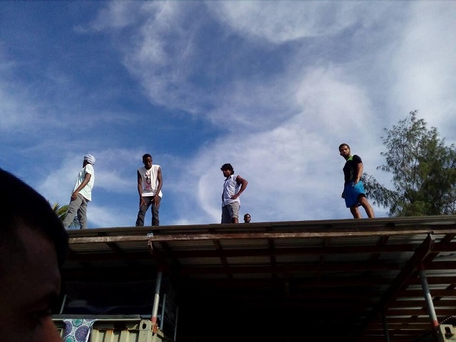 asylum seekers occupying the closed australian run immigration detention centre on papua new guinea 039 s manus island climb on top of buildings at the centre to avoid police november 23 2017 photo via reuters