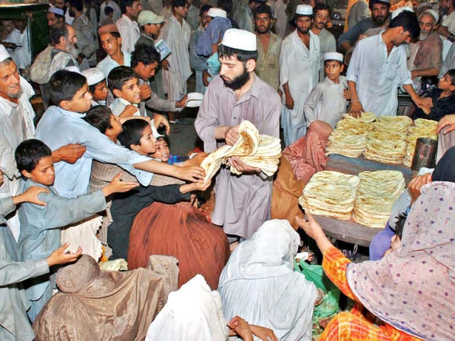 a beggar woman sits with her children while others get free food photo iqbal haider express a beggar woman sits with her children while others get free food photo iqbal haider express