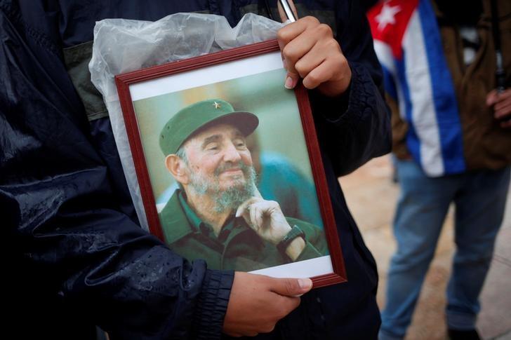 a supporter holds an image of former cuban leader fidel castro at a tribute in malaga southern spain photo reuters