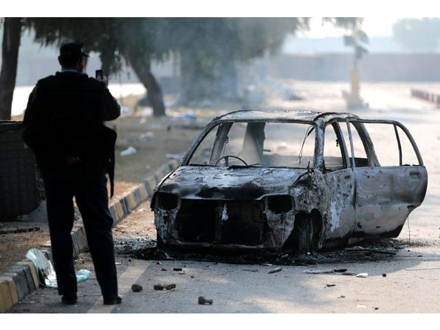 a policeman takes a picture of a car burned during clashes near the faizabad junction in islamabad pakistan november 26 2017 photo reuters a policeman takes a picture of a car burned during clashes near the faizabad junction in islamabad pakistan november 26 2017 photo reuters