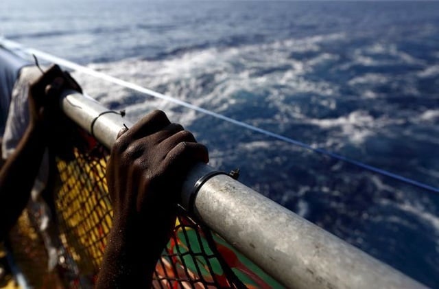 file photo a migrant holds onto a railing at the stern of the medecins sans frontiere msf rescue ship bourbon argos somewhere between libya and sicily august 8 2015 photo reuters