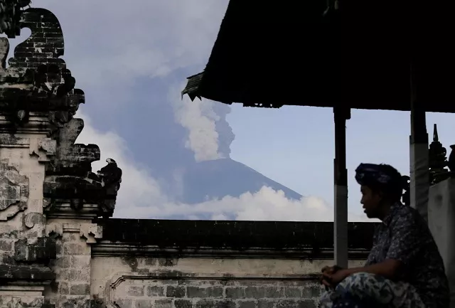 a balinese man sits as mount agung volcano erupts at lempuyang temple in karangasem bali indonesia november 27 2017 photo reuters a balinese man sits as mount agung volcano erupts at lempuyang temple in karangasem bali indonesia november 27 2017 photo reuters
