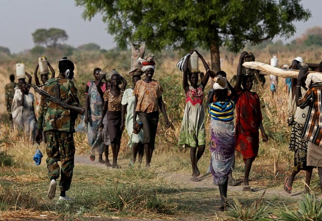 file photo a soldier walks past women carrying their belongings near bentiu northern south sudan february 11 2017 photo reuters