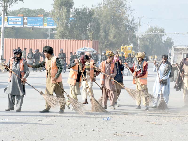 cda workers sweep expressway after the end of sit in at faizabad photo mudassar raja express