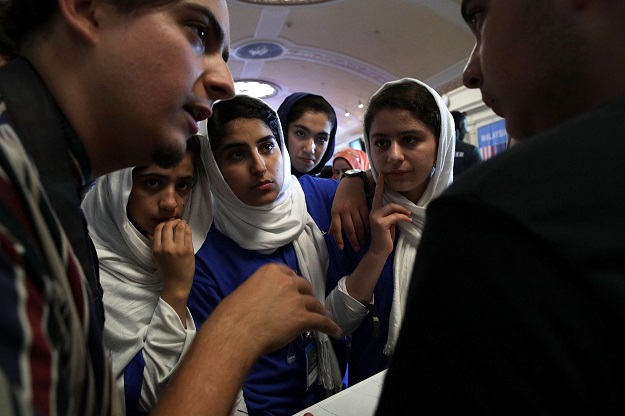 somayeh faruqi lida azizi yasimin yasinzadah and kawsar roshan of team afghanistan listen through embassy staff mojib ghaznawi s l translation as they discuss strategy with a member of team north america photo afp