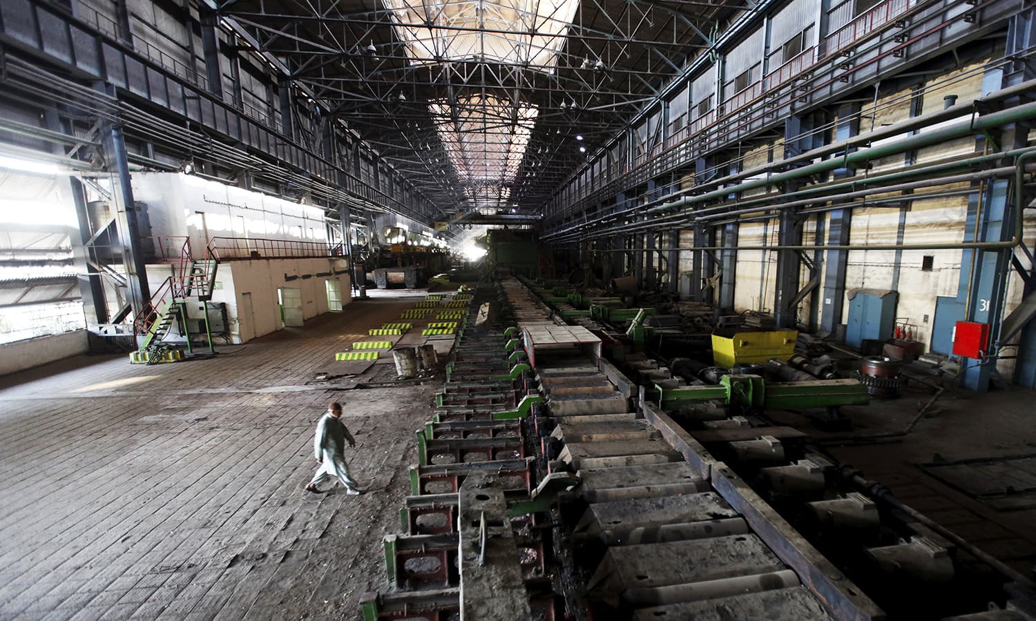 a man walks past machines at the hot strip mill department of the pakistan steel mills psm on the outskirts of karachi pakistan photo reuters file