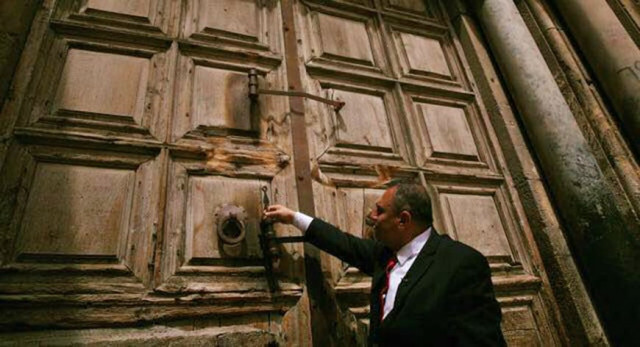a custodian of the key to the church of the holy sepulchre unlocks the door to the church in the old city of jerusalem photo al monitor a custodian of the key to the church of the holy sepulchre unlocks the door to the church in the old city of jerusalem photo al monitor