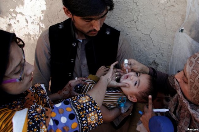 vaccination workers give a boy polio vaccine drops on a street in quetta pakistan jan 2 2017 photo voa