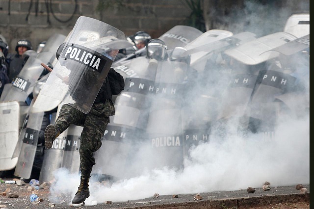 a soldier kicks a tear gas canister during a clash with supporters of salvador nasralla presidential candidate for the opposition alliance against the dictatorship as they wait for official presidential election results in tegucigalpa honduras november 30 2017 photo reuters