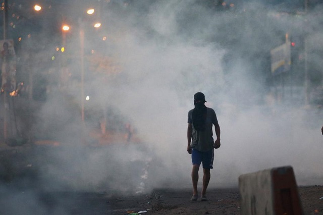 a supporter of presidential candidate salvador nasralla walks on a street during a protest caused by the delayed vote count for the presidential election at villanueva neighborhood in tegucigalpa honduras december 1 2017 photo reuters