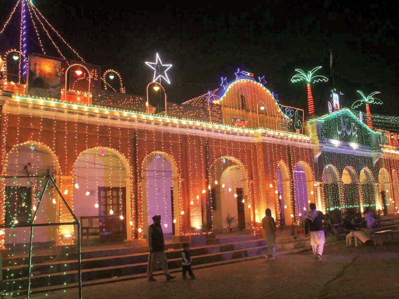 an illuminated view of buildings decorated with colourful lights in connection with eid miladun nabi in bahawalpur photo online