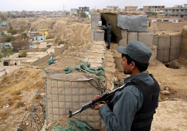 afghan police officers keep watch at their forward base on the outskirts of kunduz province afghanistan photo reuters