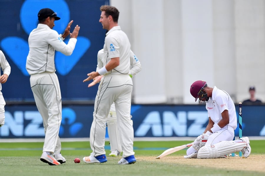 west indies 039 roston chase r sits dejected after his dismissal as new zealand 039 s matt henry c celebrates with teammate jeet raval l during day four of the first test cricket match between new zealand and the west indies at the basin reserve in wellington on december 4 2017 photo afp