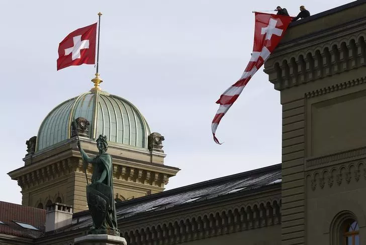 workers hang up a swiss flag on the swiss parliament building in bern switzerland photo reuters workers hang up a swiss flag on the swiss parliament building in bern switzerland photo reuters