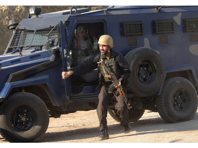 a police commando escorts rescued staff members of an agriculture training institute sit in a armoured vehicle after an attack by taliban militants in peshawar on december 1 2017 photo afp