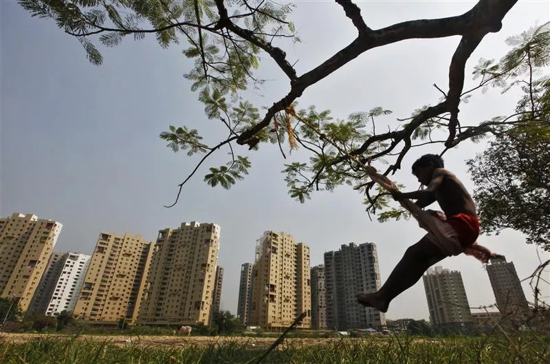 a boy plays on a swing suspended from a tree in front of a residential estate under construction photo reuters a boy plays on a swing suspended from a tree in front of a residential estate under construction photo reuters