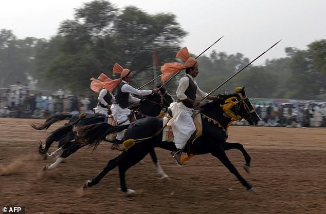 festooned with garlands and colourful bridles turbaned riders mounted on horseback in full gallop lower their lances at tiny wooden blocks as they practice the centuries old tradition of tent pegging photo afp