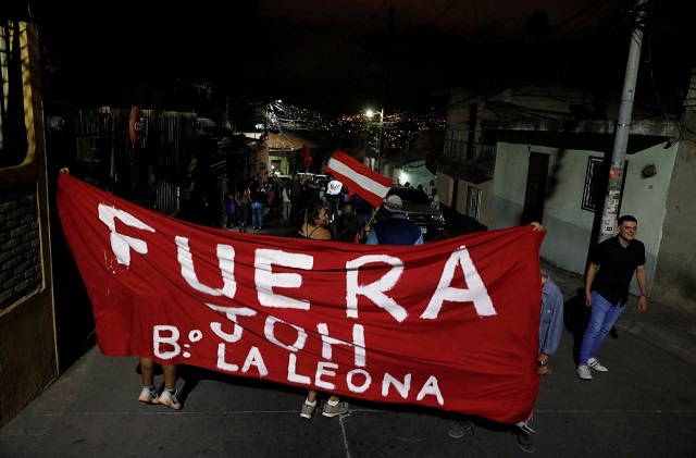 people hold up a banner at a protest during curfew while the country is still mired in chaos over a contested presidential election in tegucigalpa honduras december 5 2017 the banners reads quot out joh quot a word referring to national party presidential candidate juan orlando hernandez photo reuters