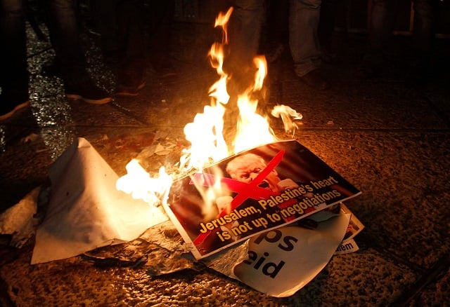 palestinian demonstrators burn posters of the us president in bethlehem 039 s manger square in protest to him declaring jerusalem as israel 039 s capital on december 6 2017 photo afp