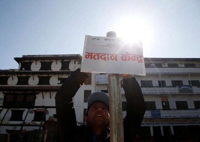 an election officer sets up a sign that reads quot polling station quot a day ahead of the parliamentary and provincial elections in kathmandu nepal december 6 2017 photo reuters