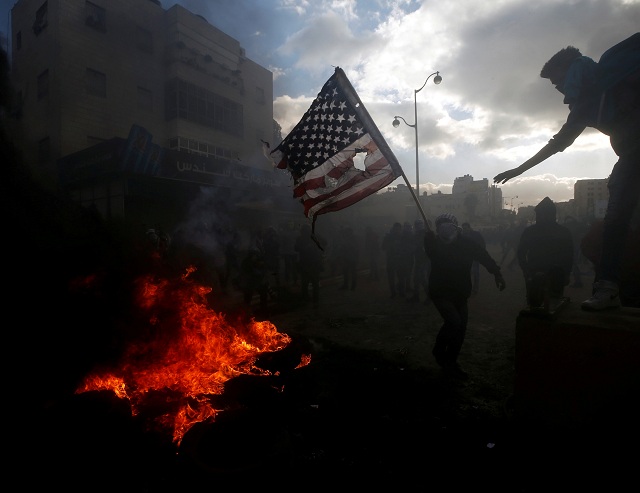 a palestinian protester prepares to burn a us flag during clashes with israeli troops near the jewish settlement of beit el near the west bank city of ramallah december 7 2017 photo reuters