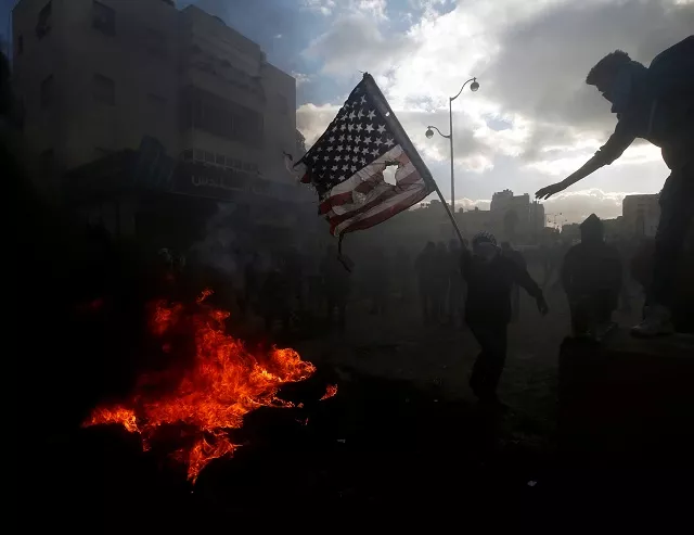 a palestinian protester prepares to burn a us flag during clashes with israeli troops near the jewish settlement of beit el near the west bank city of ramallah december 7 2017 photo reuters a palestinian protester prepares to burn a us flag during clashes with israeli troops near the jewish settlement of beit el near the west bank city of ramallah december 7 2017 photo reuters