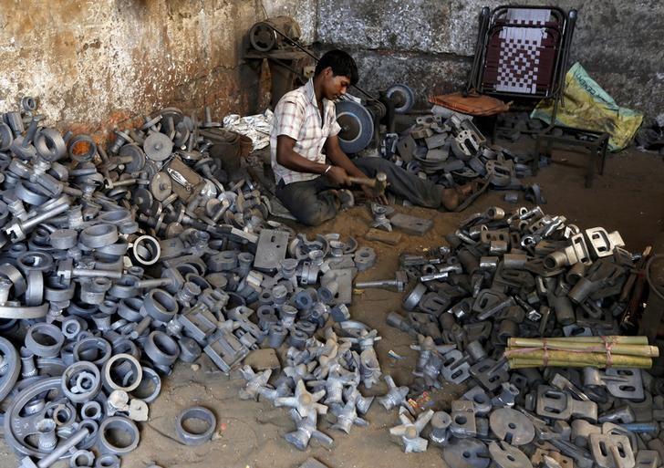 a worker separates casting joints of gearboxes inside a small scale automobile manufacturing unit photo reuters