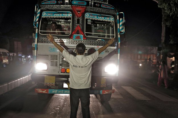 a member of the bhartiya gau raksha dal cow vigilante group raises his arms to stop a truck at a roadblock set up in the northern indian city of chandigarh in early july photo reuters