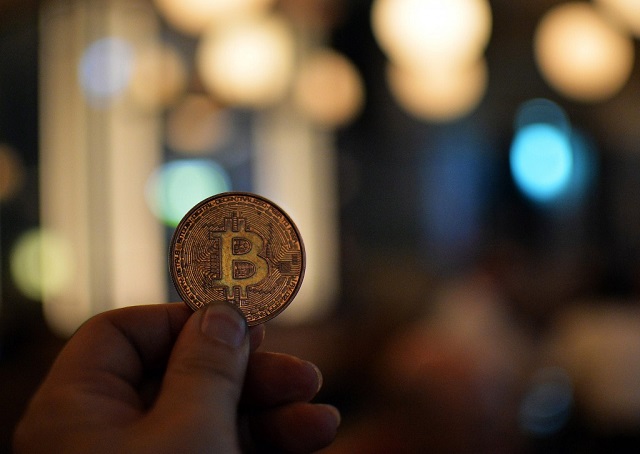 a man holds a bitcoin medal as members of bitcoin trading club hold a meeting in tokyo photo afp