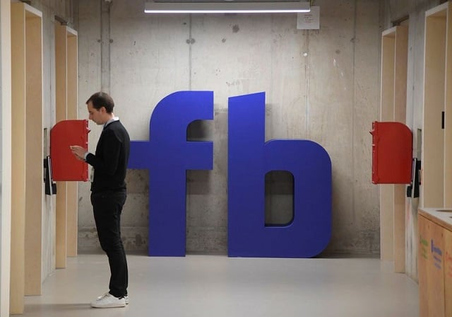 a man waits for an elevator in front of a logo at facebook 039 s headquarters in london photo reuters