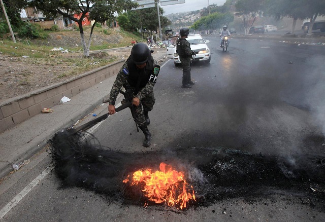 a military police removes a burning tire from a barricade settled by opposition supporters during a protest after the country 039 s electoral tribunal declared conservative president juan orlando hernandez the official winner of a bitterly contested presidential vote in tegucigalpa honduras december 18 2017 photo reuters