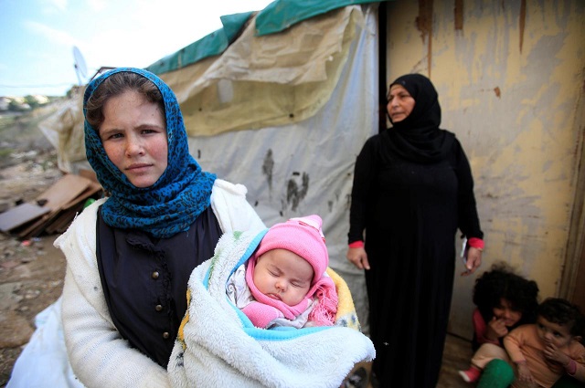 a syrian refugee woman holds a child in ain baal village near tyre in southern lebanon november 27 2017 photo reuters