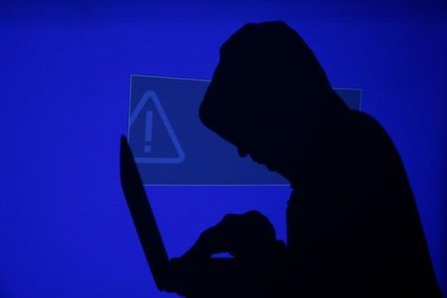 a hooded man holds a laptop computer as blue screen with an exclamation mark is projected on him in this illustration picture photo reuters a hooded man holds a laptop computer as blue screen with an exclamation mark is projected on him in this illustration picture photo reuters