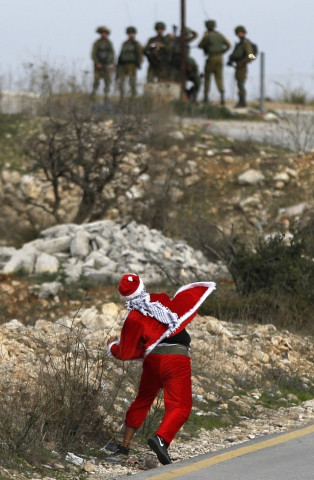 a palestinian protester dressed up as father christmas throws stones towards israeli soldiers during clashes at atarot checkpoint on the northern outskirts of jerusalem on december 19 2017 one day after the united states vetoed a draft un resolution rejecting president donald trump 039 s decision to recognize jerusalem as israel 039 s capital after all 14 other security council members backed the measure photo afp a palestinian protester dressed up as father christmas throws stones towards israeli soldiers during clashes at atarot checkpoint on the northern outskirts of jerusalem on december 19 2017 one day after the united states vetoed a draft un resolution rejecting president donald trump 039 s decision to recognize jerusalem as israel 039 s capital after all 14 other security council members backed the measure photo afp