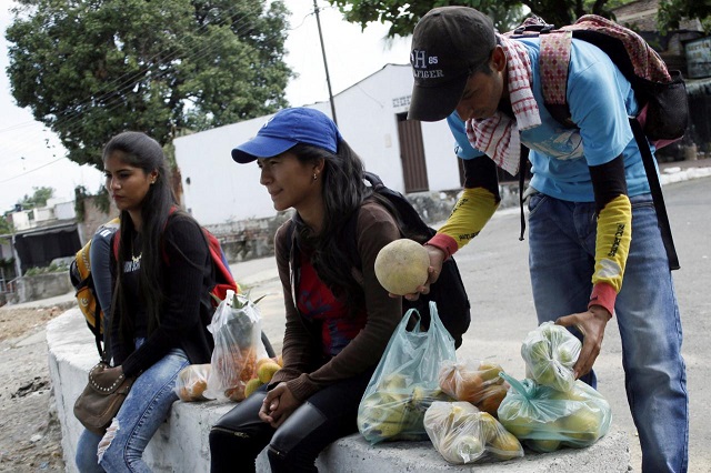 marlon carrillo r organizes the fruits bought in venezuela as he waits for customers in cucuta colombia december 15 2017 photo reuters